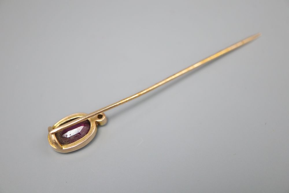 An Edwardian yellow metal, garnet and diamond set stick pin, 64mm, gross 2.2 grams.